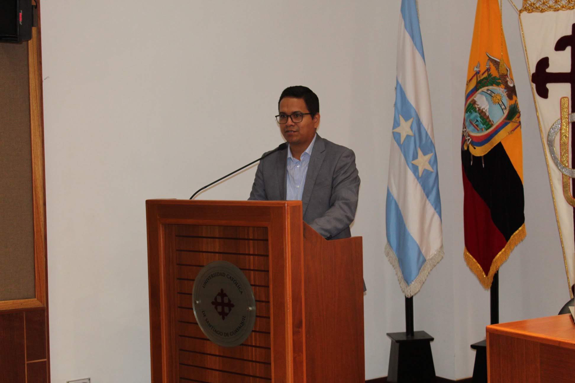 Byrone Tomalá exponiendo desde un atril
